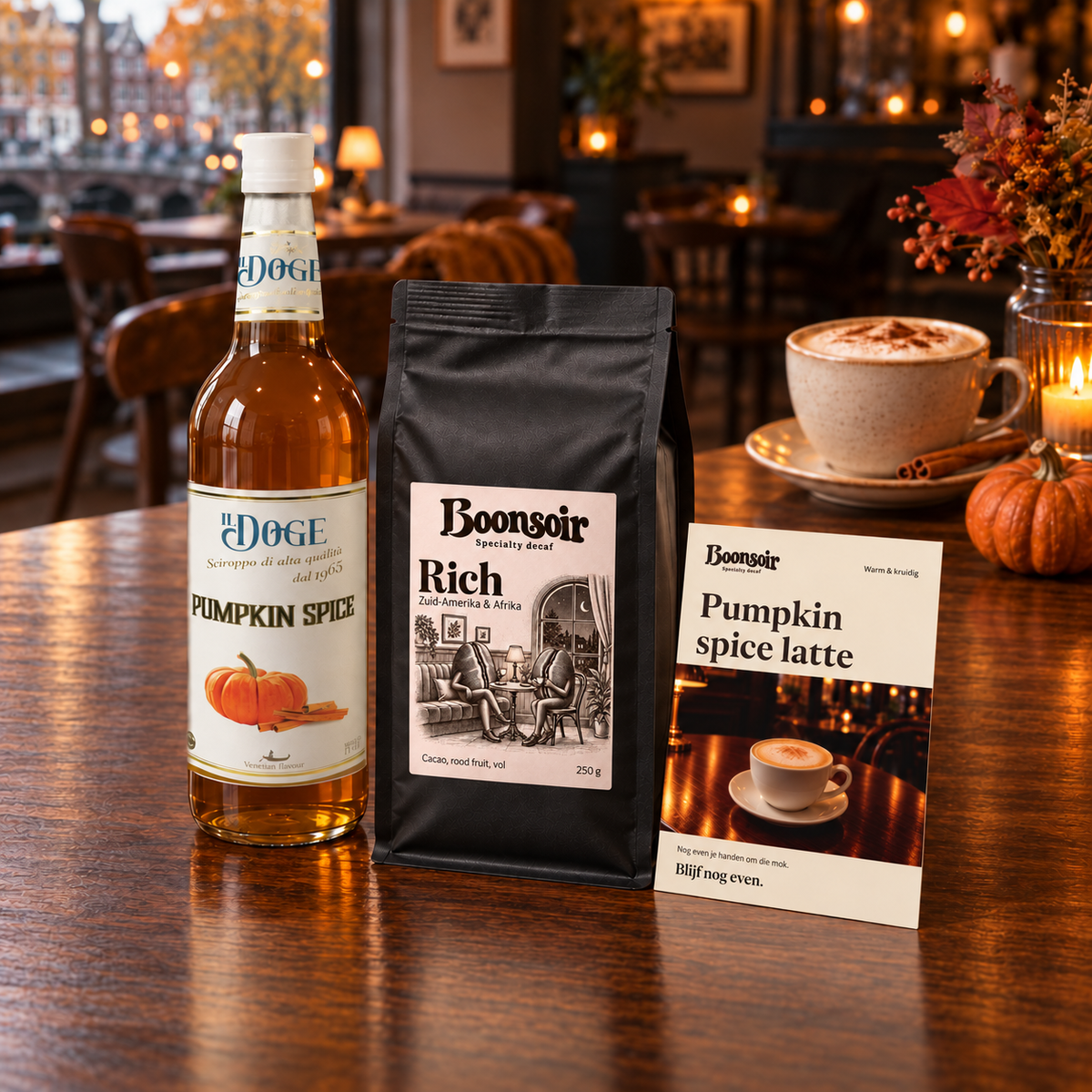 Productvisualisatie: één Rich 250 g, Il Doge Pumpkin Spice-siroop 70 cl en de A6-receptkaart op een cafétafel.